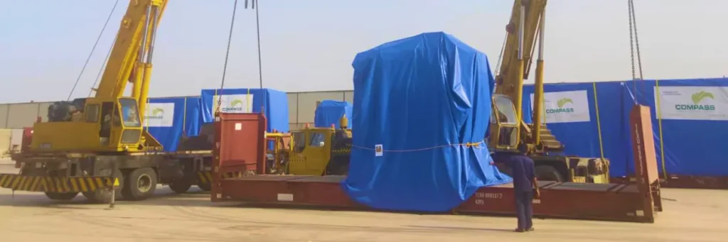 Covered cargo being lifted by cranes